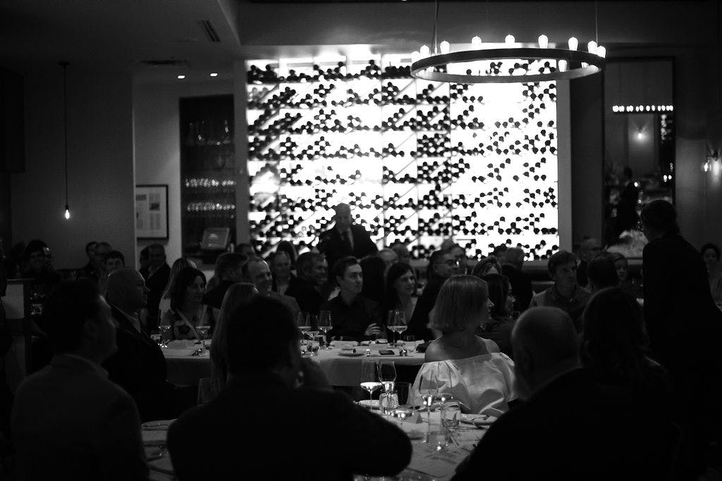 a group of people sitting at a table in front of a crowd