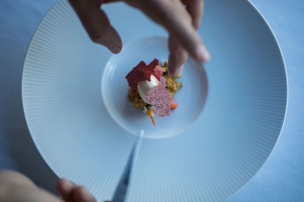 a person holding a piece of cake on a plate