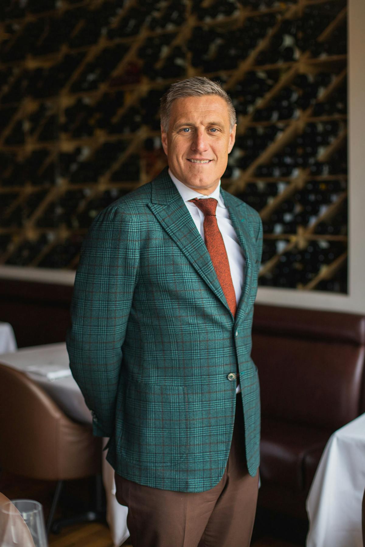 a person wearing a suit and tie smiling at the camera