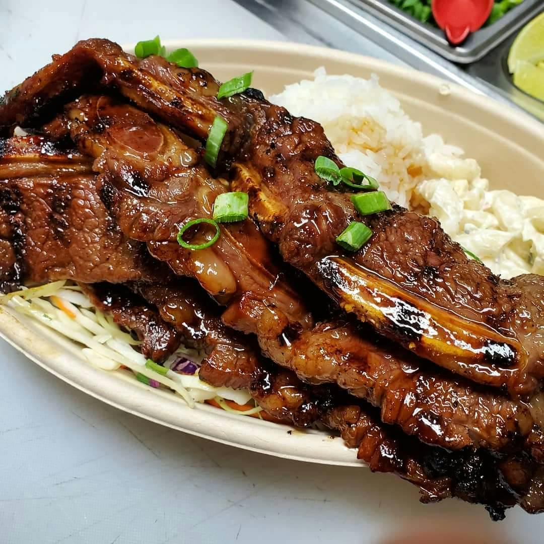a close up of a plate of food with rice meat and vegetables