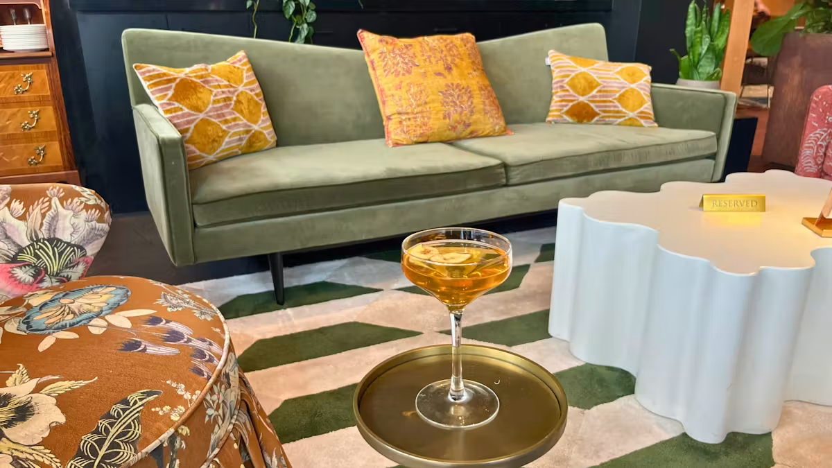 a glass of liquid on a tray in front of a couch