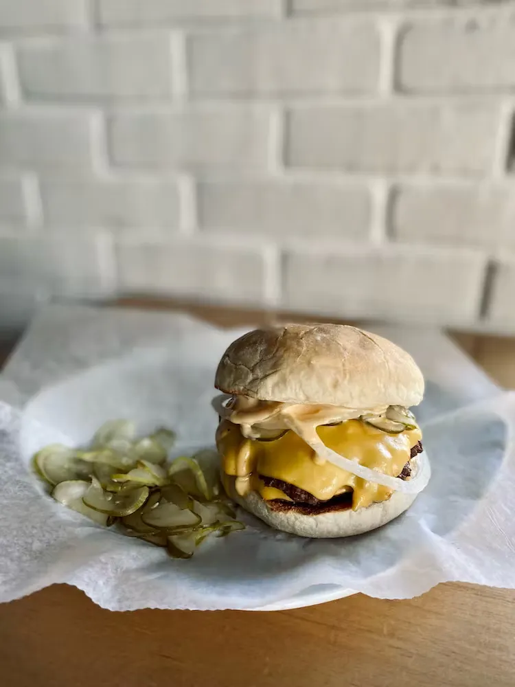 a half eaten sandwich sitting on top of a wooden table