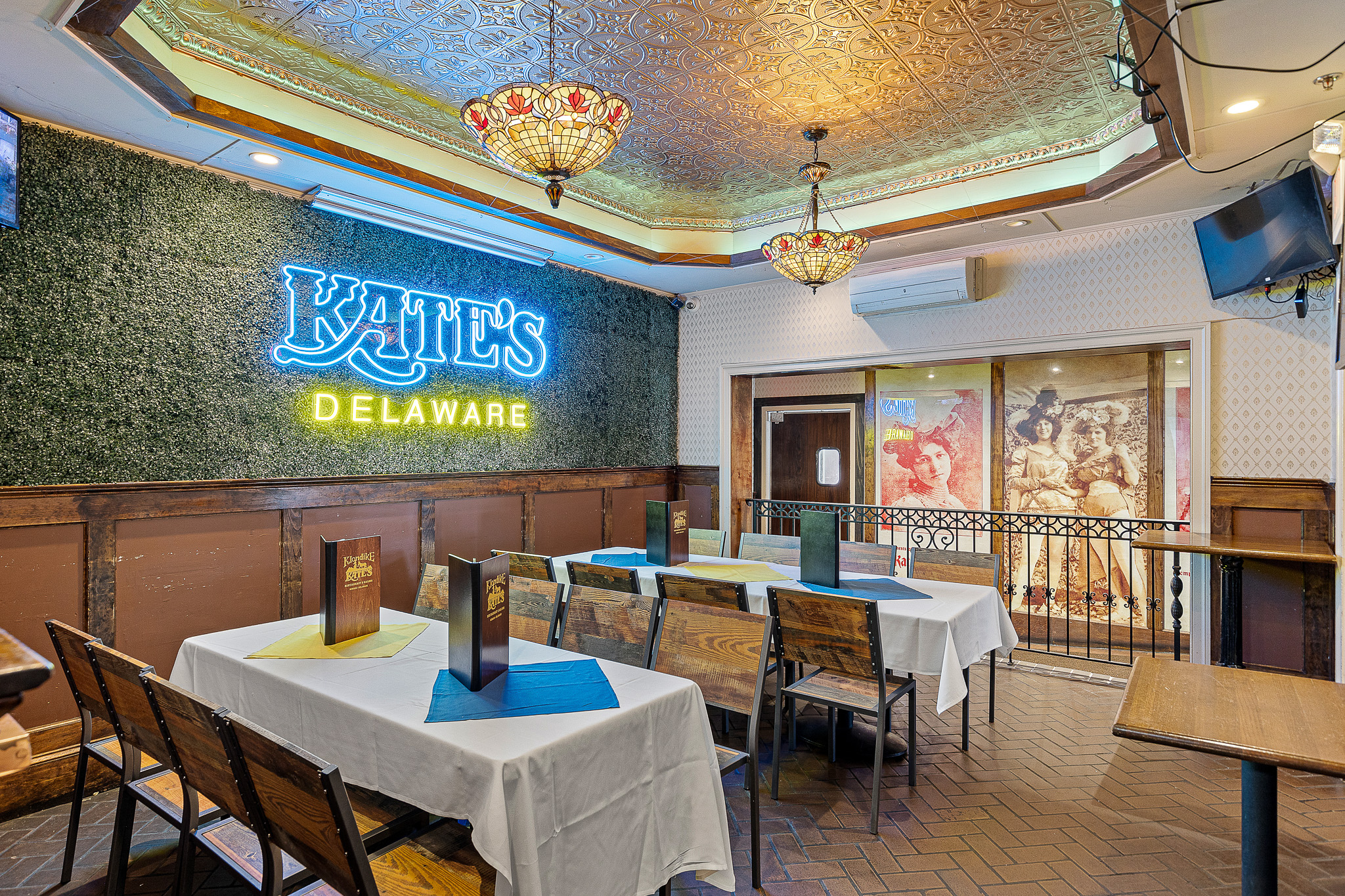 Private event room set with white-linen tables under Tiffany lighting at Klondike Kate's historic engagement party venue in Newark, Delaware