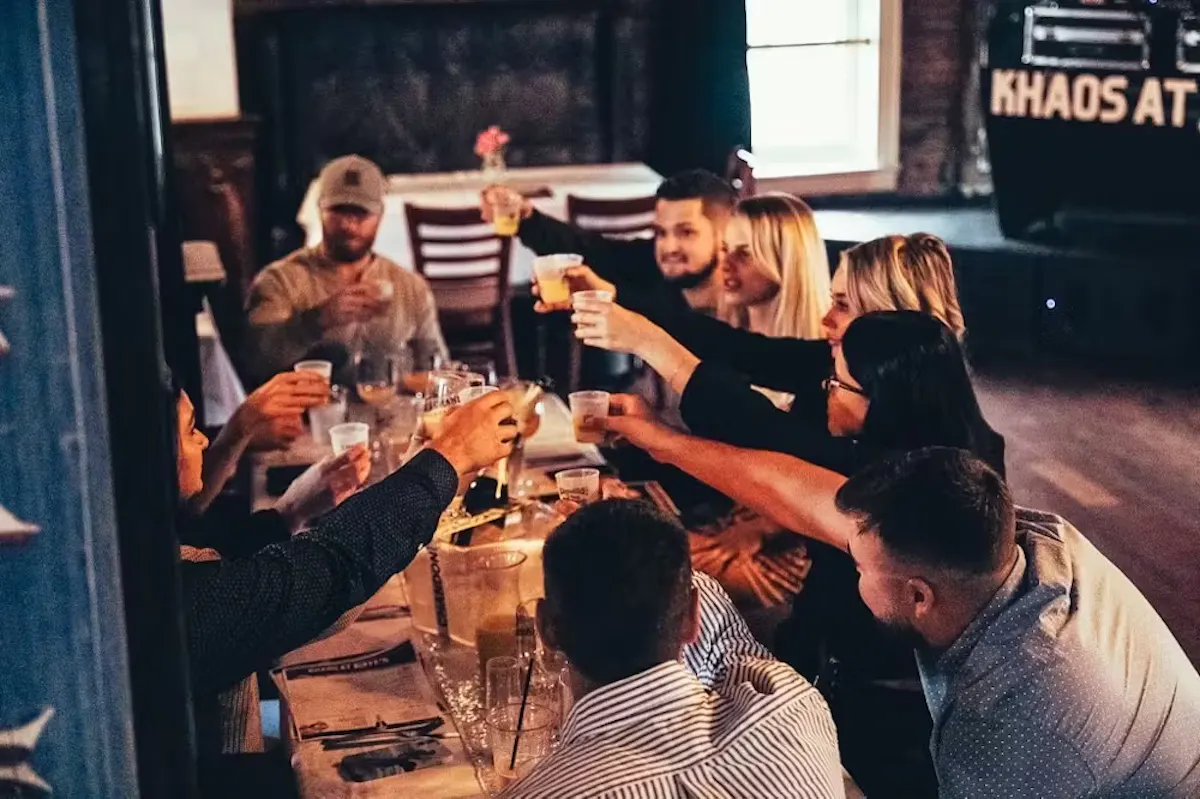 a group of people are drinking from a wine glass