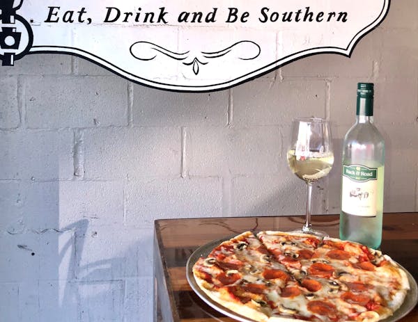 Pizza and bottle of wine with a glass on the side