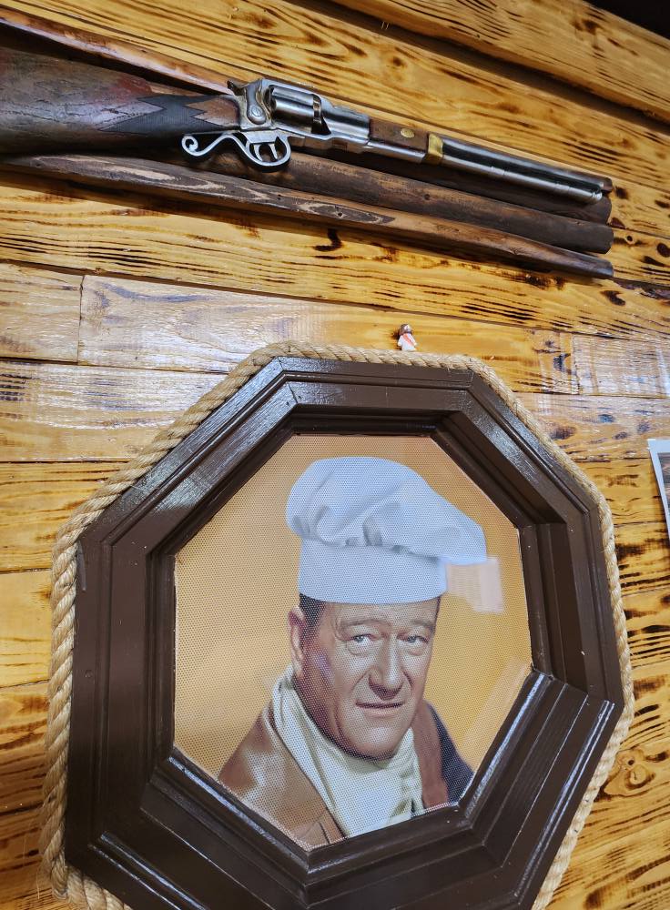 a picture of a man in a hat and a gun on a wall
