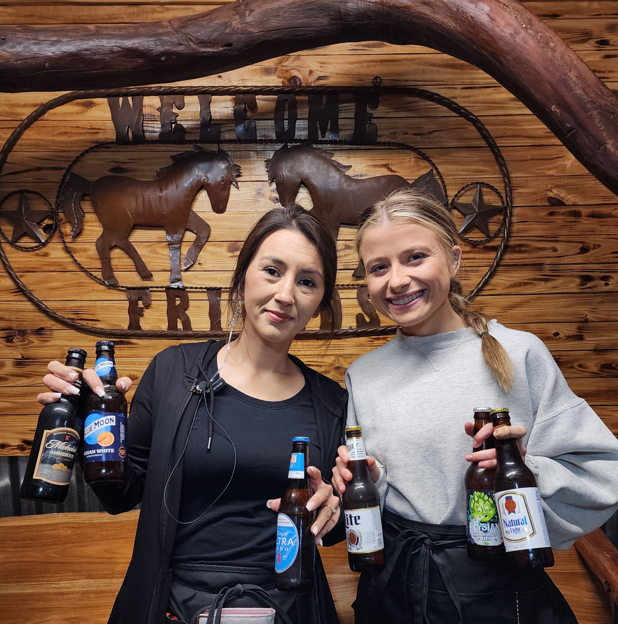 two women holding bottles of beer