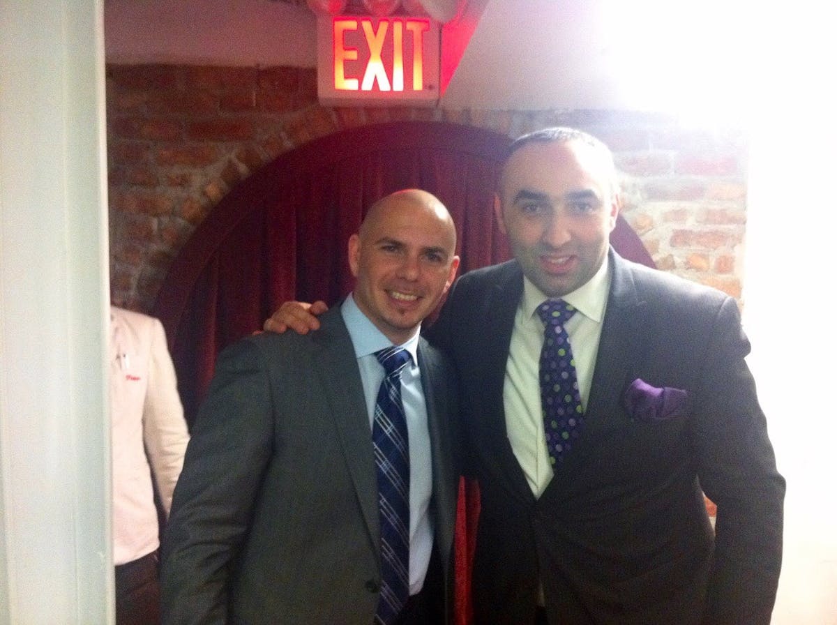 Pitbull wearing a suit and tie posing for a photo