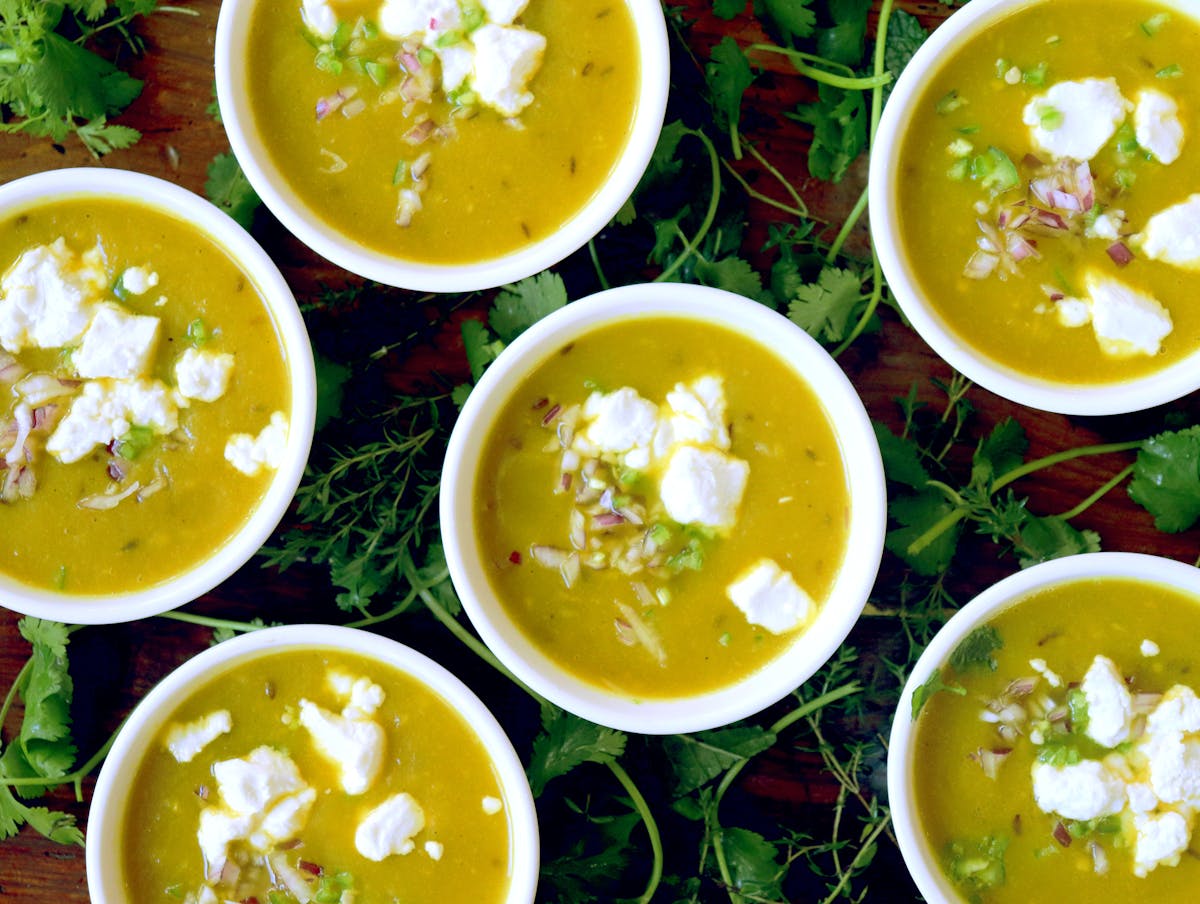 a bowl of soup with a sandwich and salad on a plate