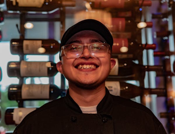 a man wearing glasses and smiling at the camera