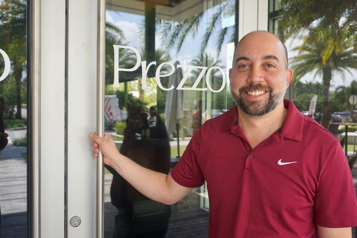 a man standing in front of a window posing for the camera