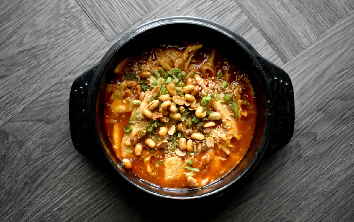 a bowl of food sitting on top of a wooden table
