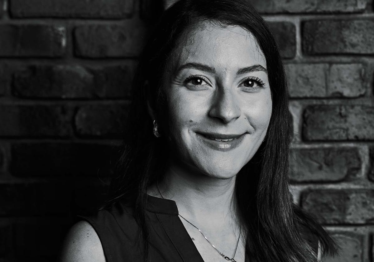 a person standing in front of a brick wall