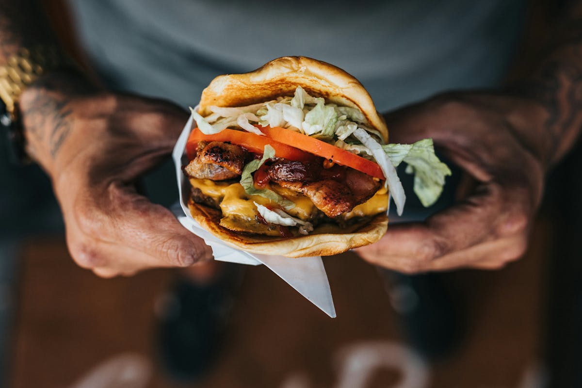 a close up of a person holding a sandwich in his hand