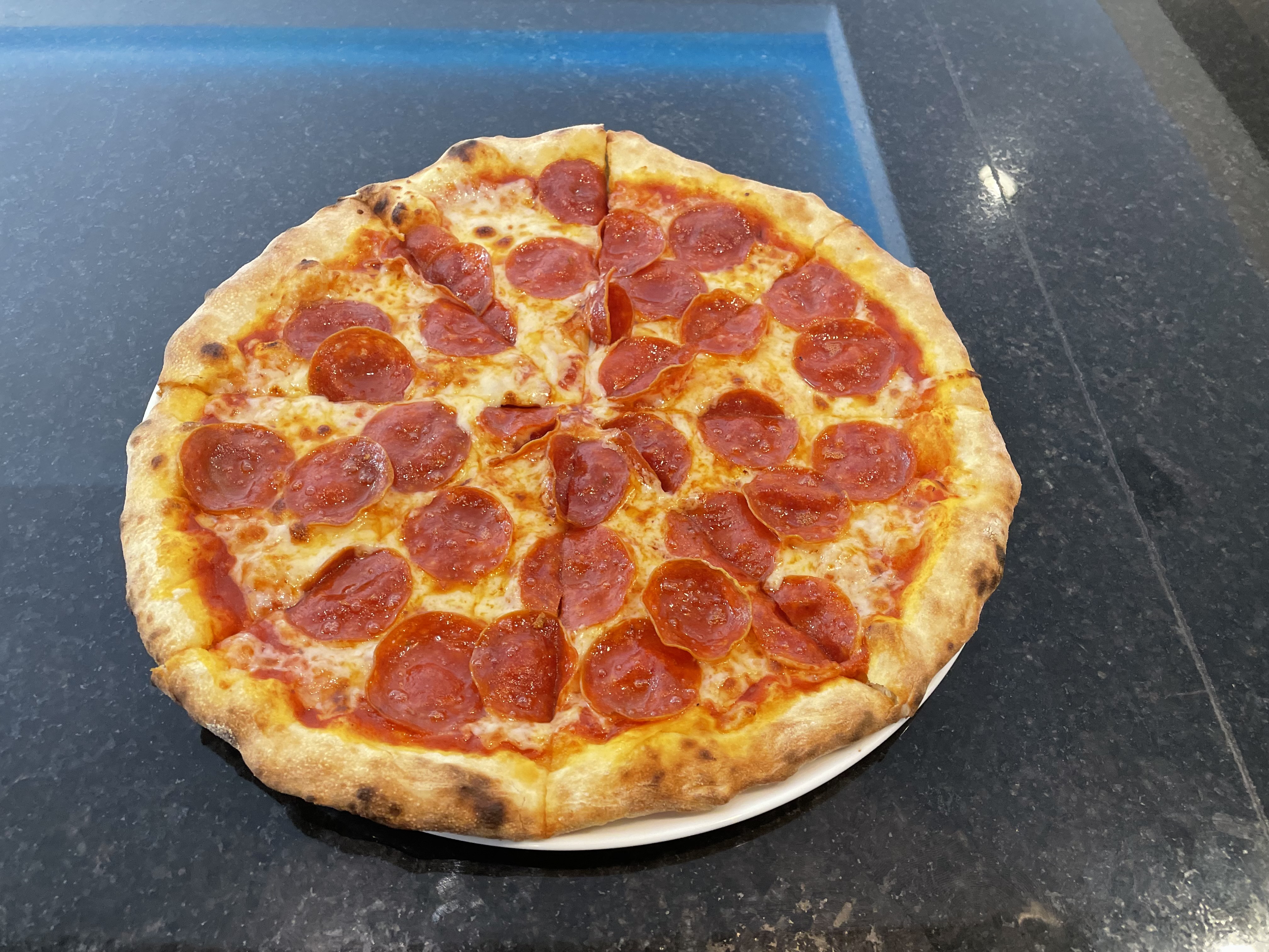 a close up of a pepperoni pizza sitting on top of a pan