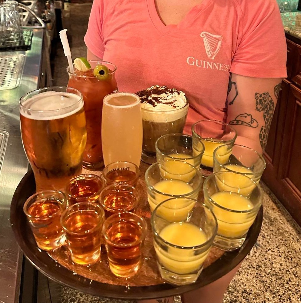a person holding a glass of beer on a table