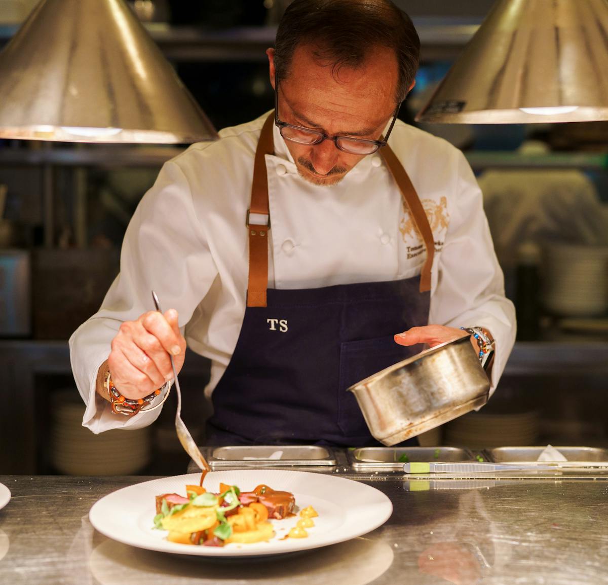 a man plating food on a dish