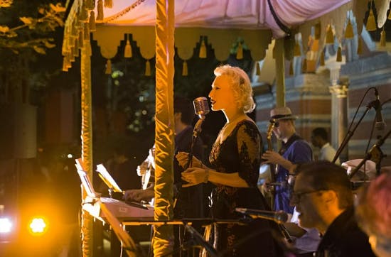 a group of people standing in front of a carousel