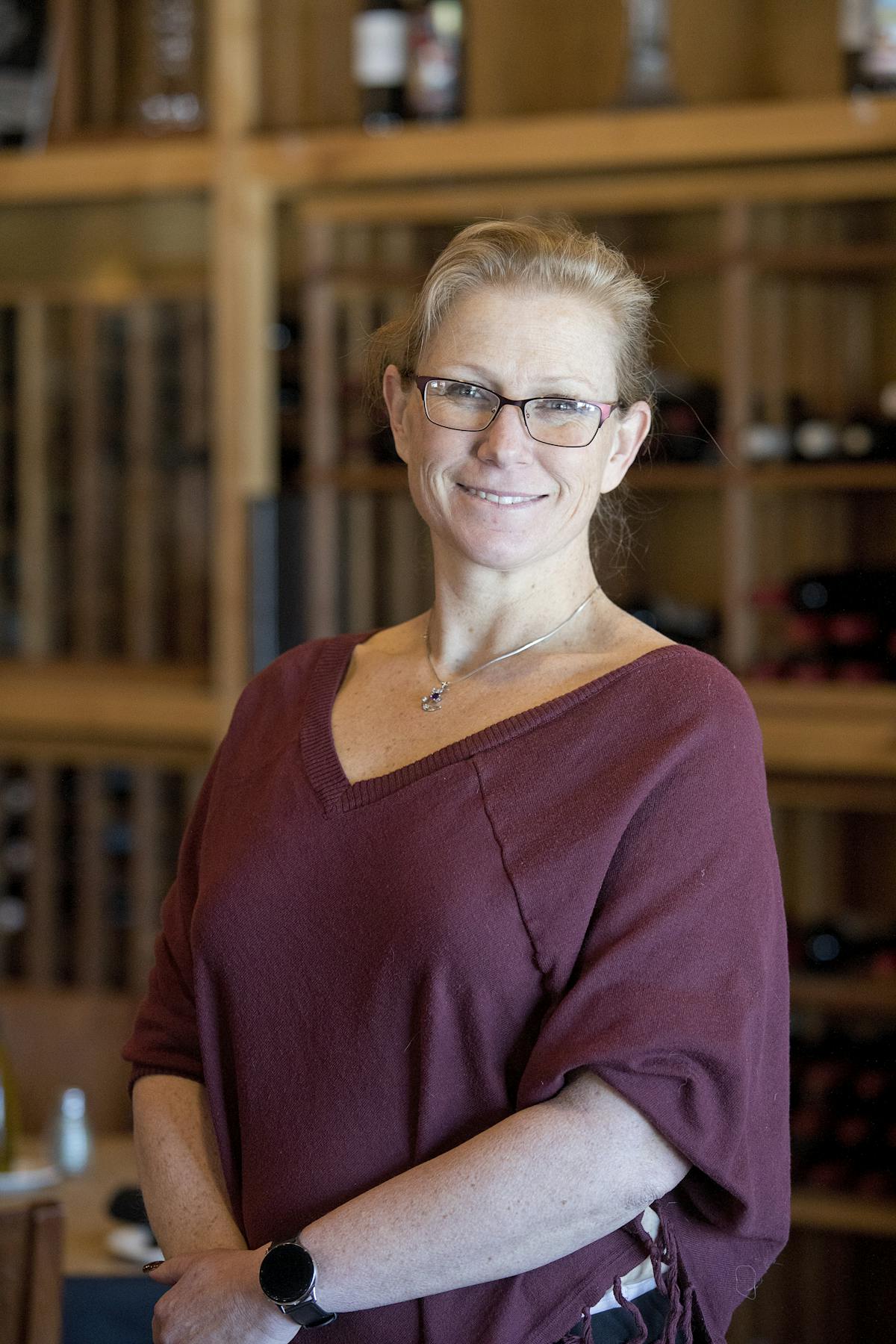 a person wearing glasses and smiling at the camera