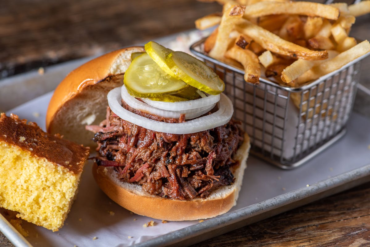 a sandwich is sitting on the side of fries