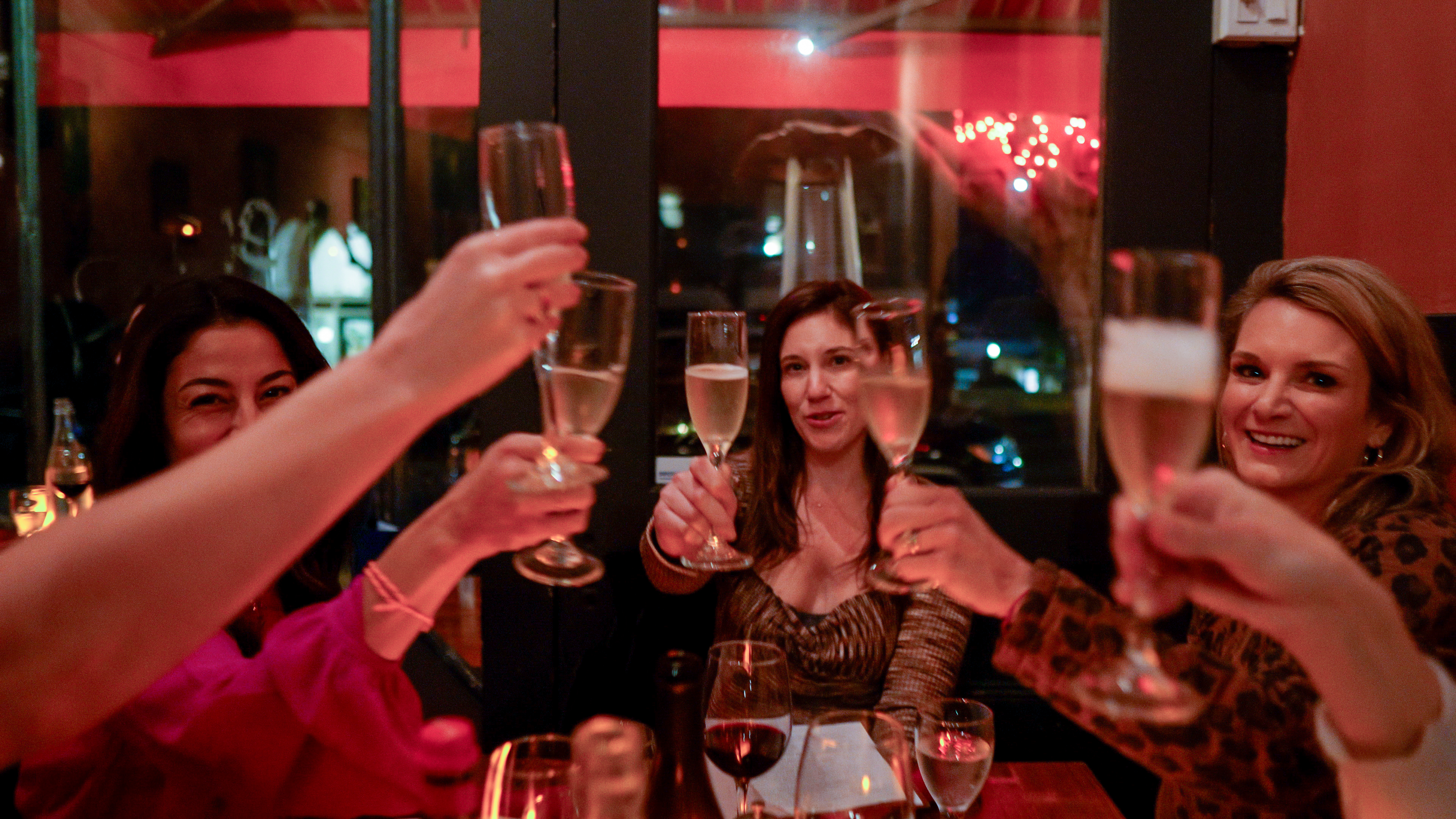 a couple of people are drinking from a wine glass