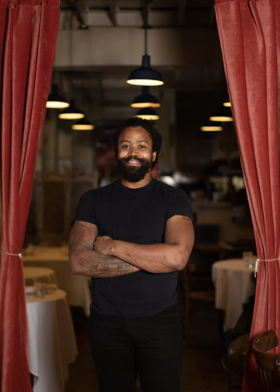 a man standing in front of a curtain