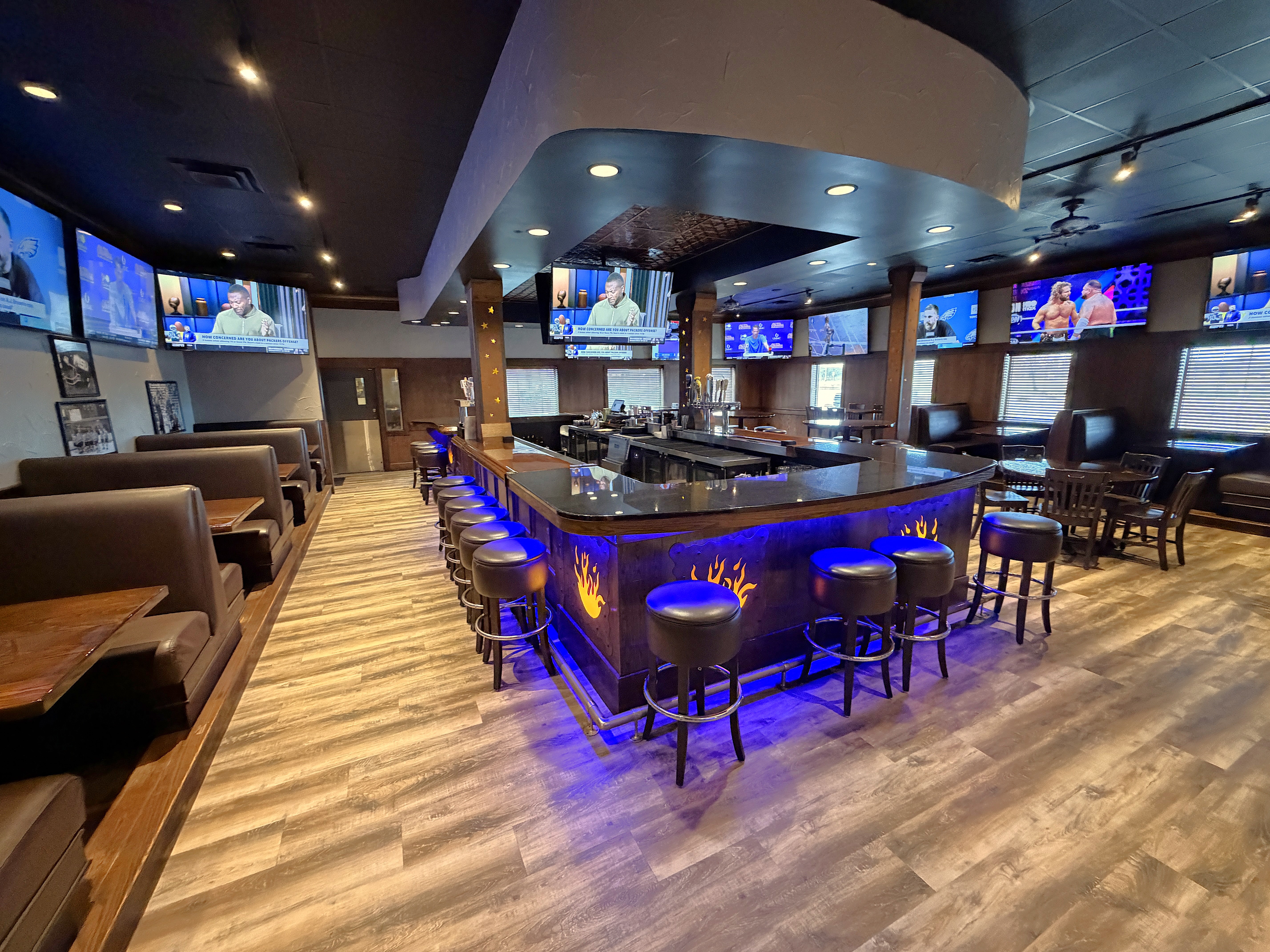 a bar with a bar stools and a television