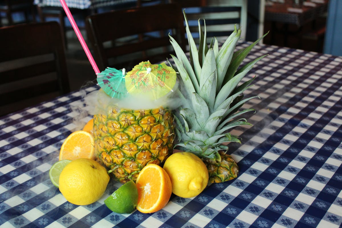 a pineapple and a vase of flowers on a table