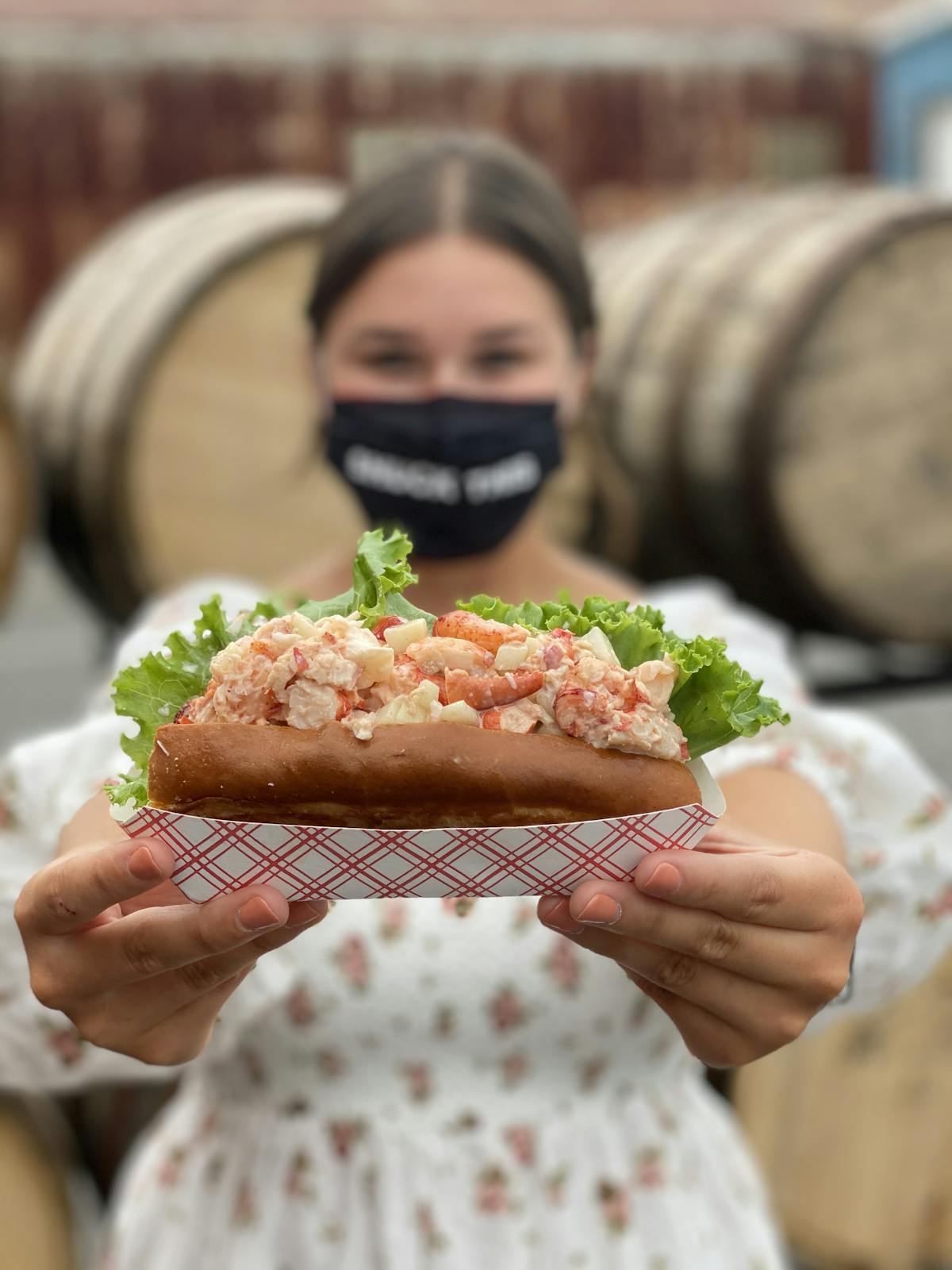 a person holding a lobster roll