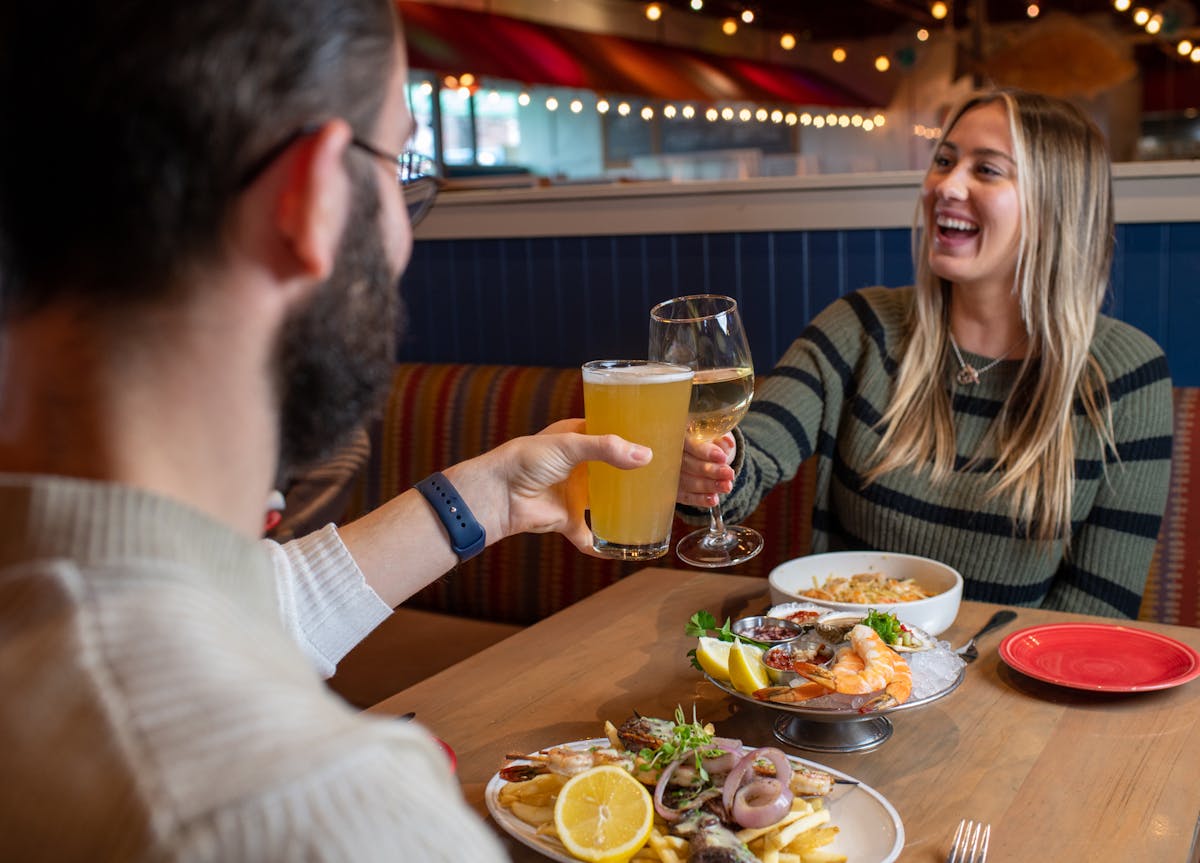 a man and a woman sitting at a table with a plate of food