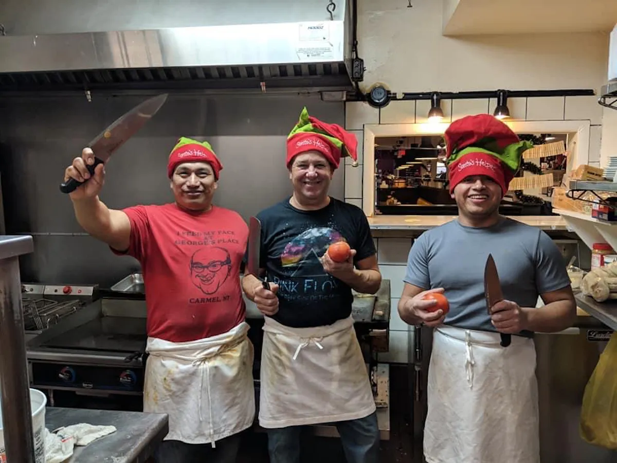 a group of people standing in a kitchen