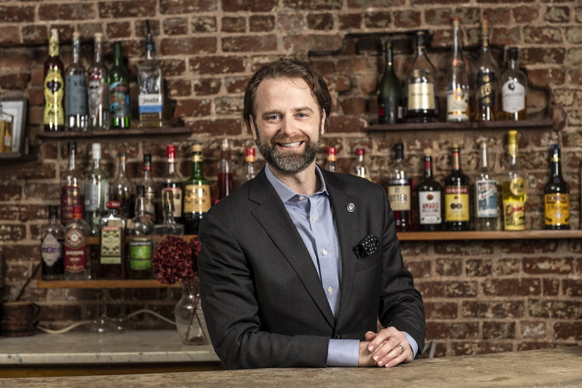 a man standing behind a bar