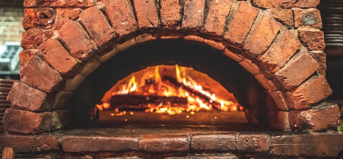 a stone oven next to a fireplace