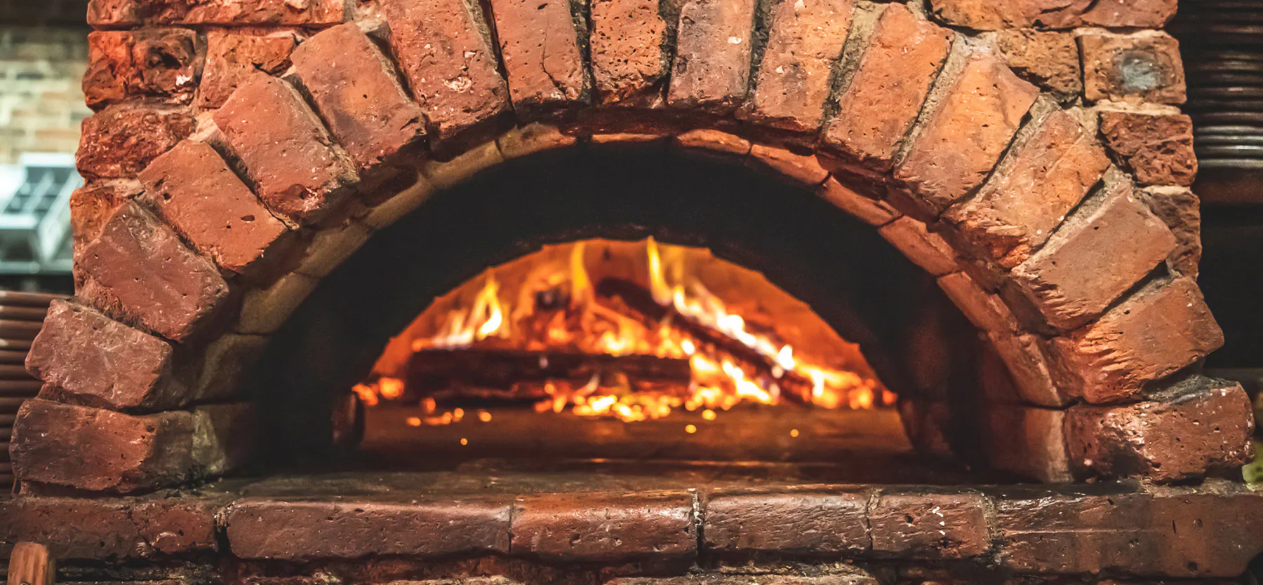 a stone oven next to a fireplace