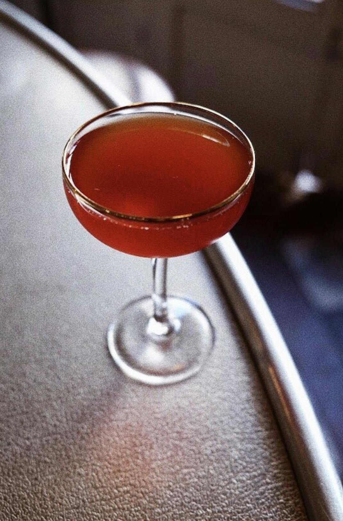 a close up of a brown cocktail in a coupe glass