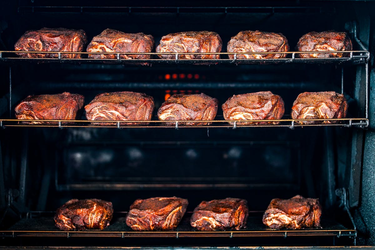 a bunch of hot dogs cooking on a grill