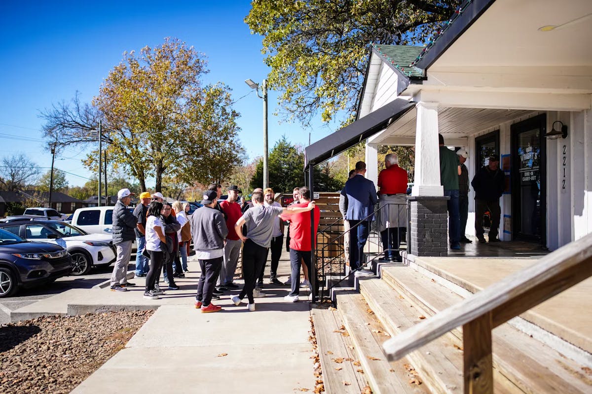 a group of people sitting at a table in front of a building