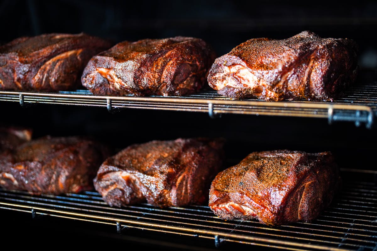 a group of meat cooking on a grill