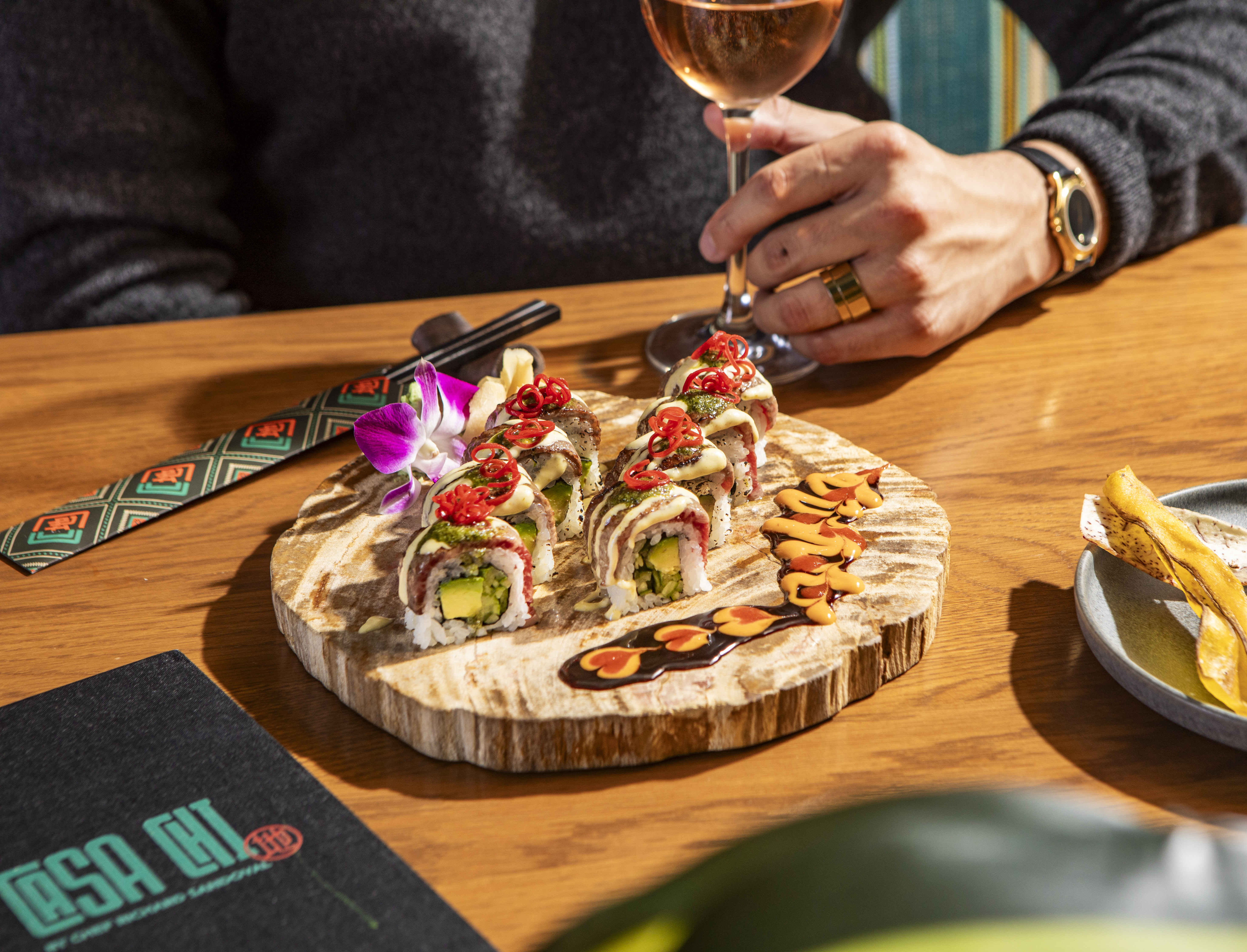 a person sitting at a table with wine glasses