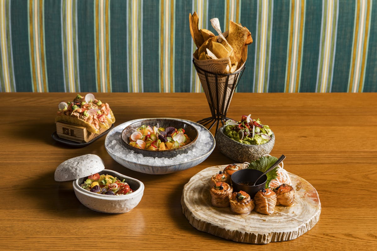 a vase sitting on top of a wooden table topped with plates of food