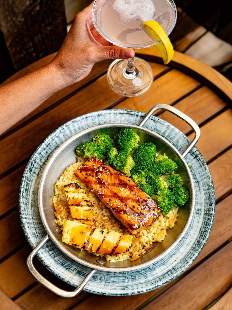 a person pouring a glass of wine into a bowl of food