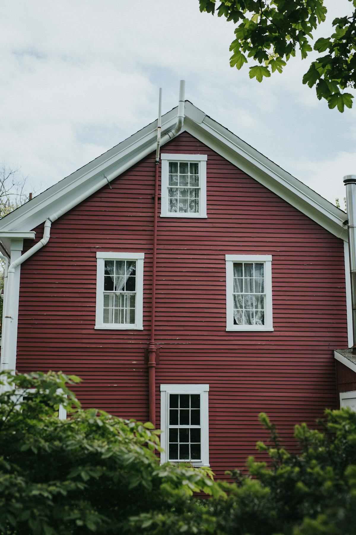 a house with bushes in front of a brick building