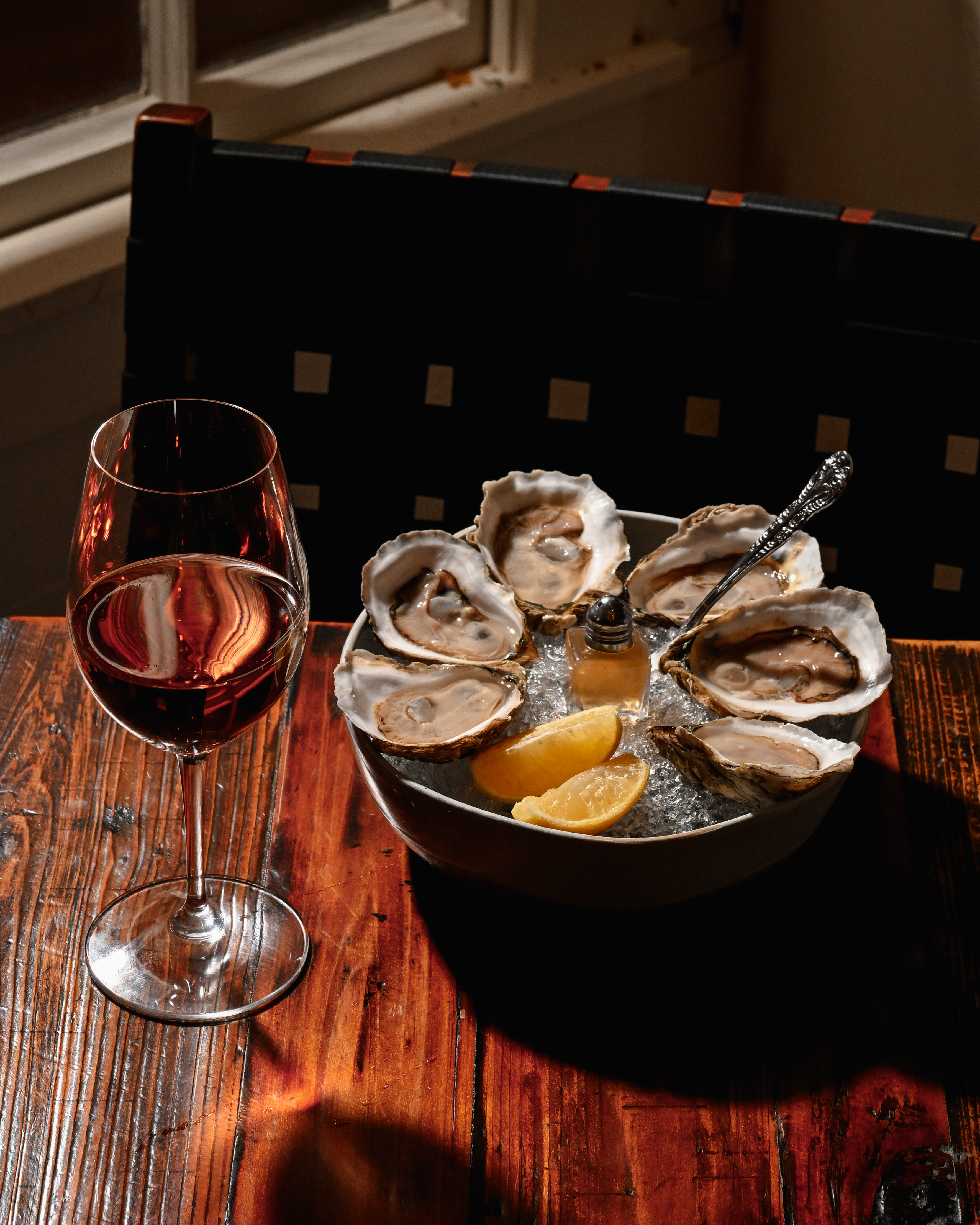 a bowl of oysters and a glass of wine