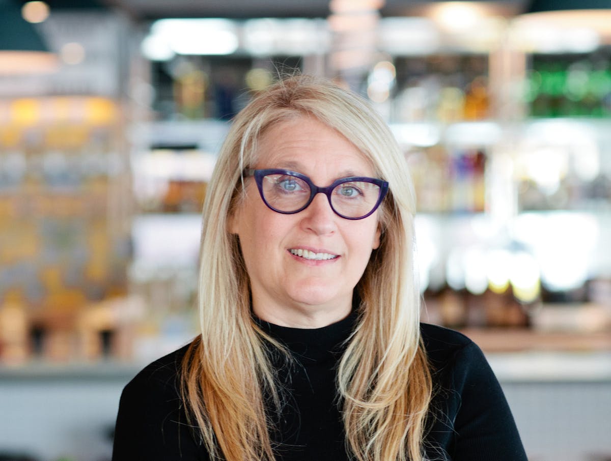 a woman wearing glasses and smiling at the camera