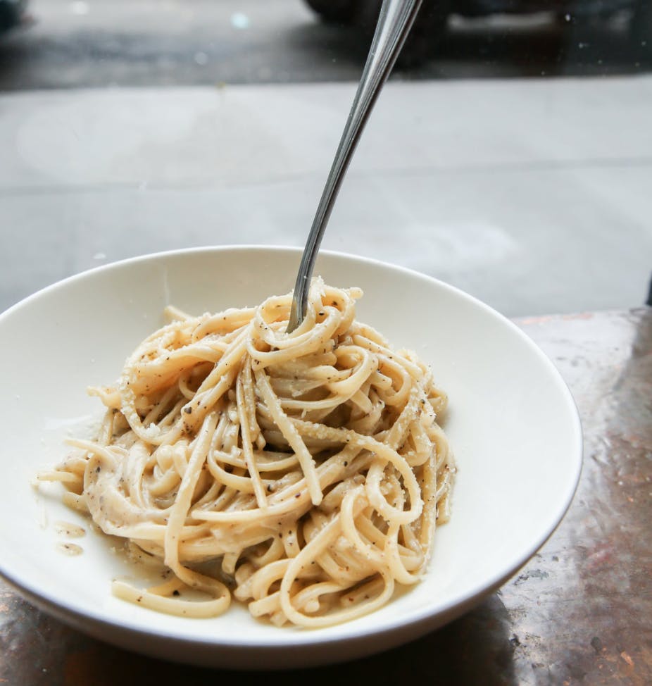 a bowl of pasta sits on a plate