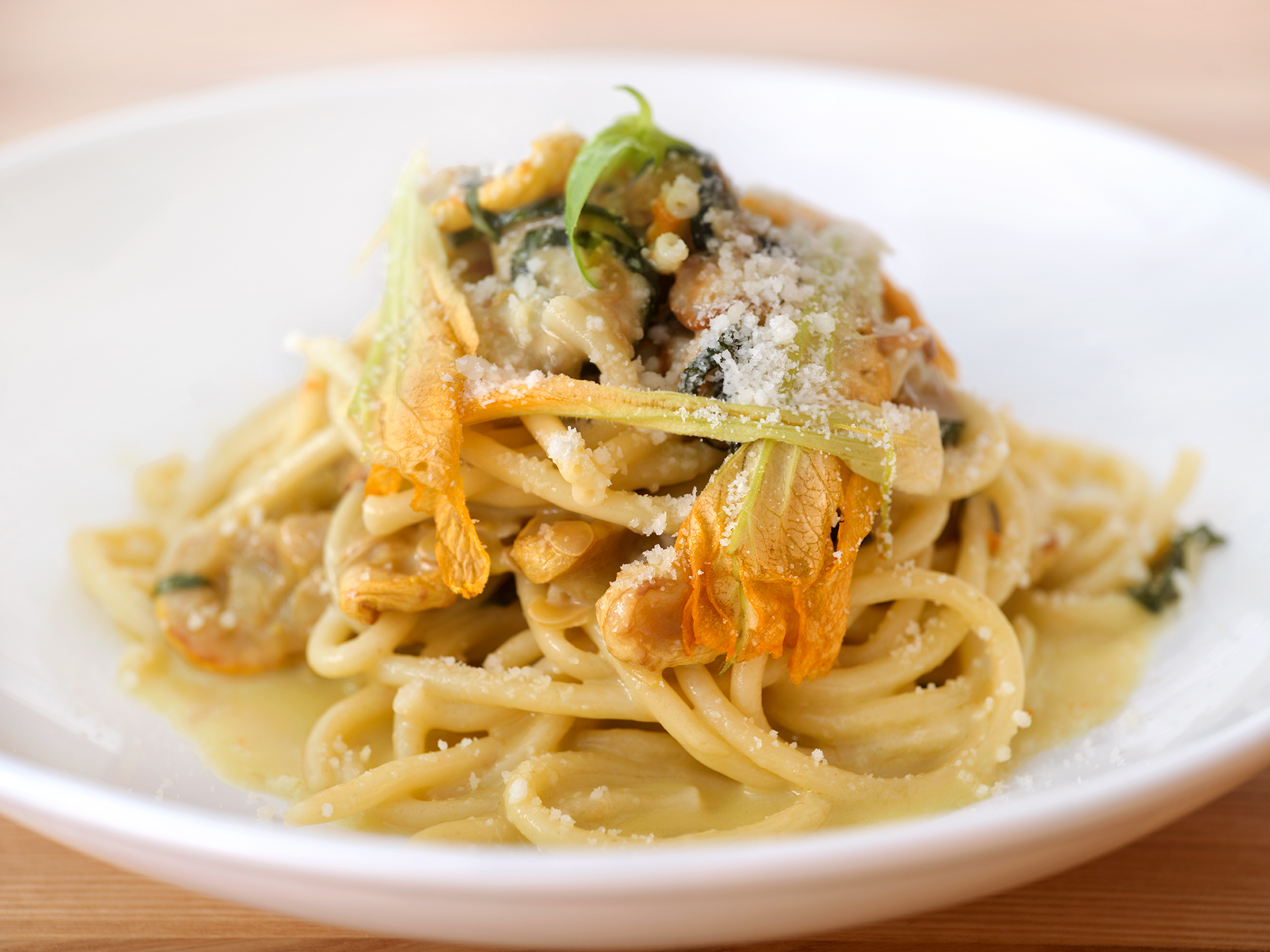 a plate of pasta with cheese and vegetables