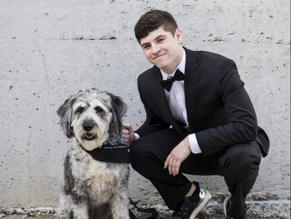 a man wearing a wet suit holding a dog