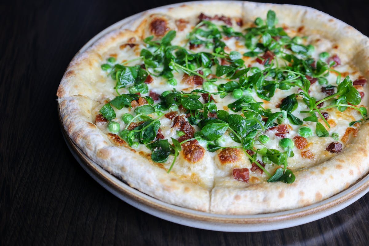 a pizza sitting on top of a wooden table