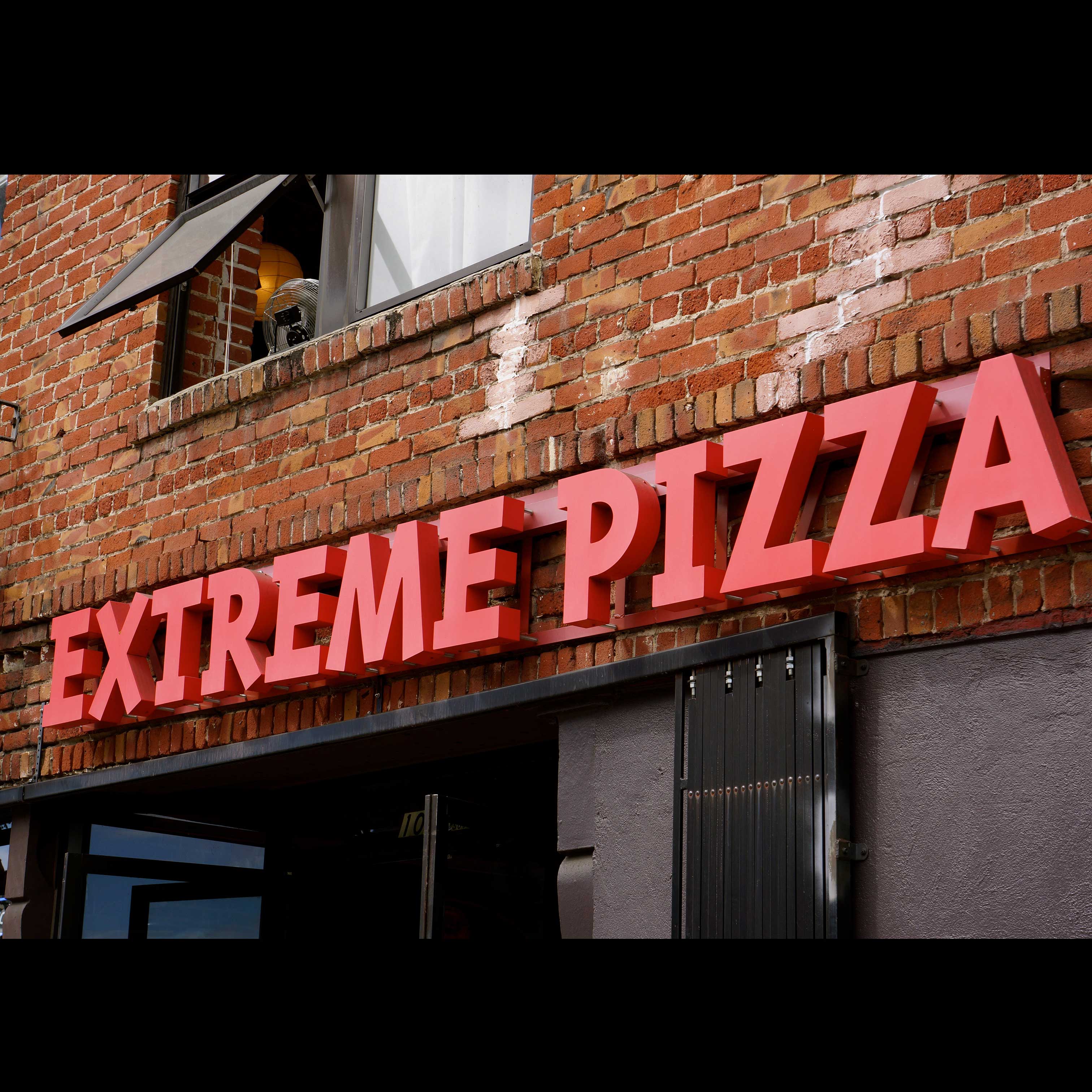 Store front with extreme pizza logo at the top