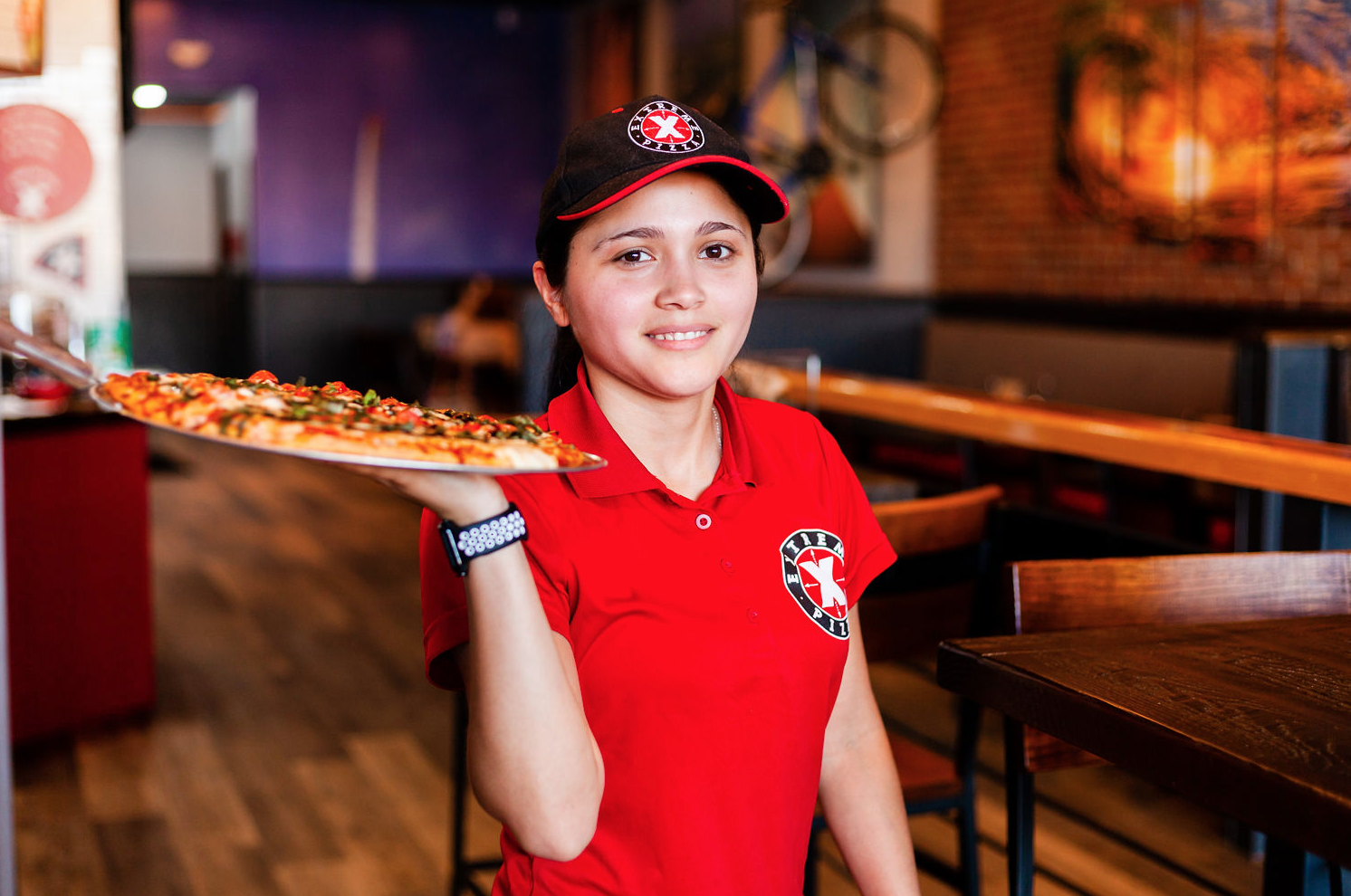a woman holding a pizza